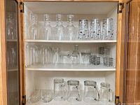 cabinet view showing various glass drinkware types on three shelves