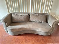 Front view of curved brown/beige sofa with two back cushions