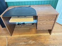 Overall view of laminate desk with drawers, keyboard tray, cables visible