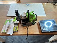 Grex compressor, regulator, hose fittings, cleaning brush set and DVD on bench