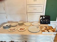 Overview of all dishware on table including bowls, plates, platters and boxed shell servers