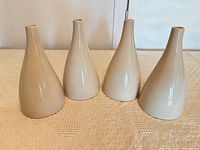 Four matching cream ceramic vases upright