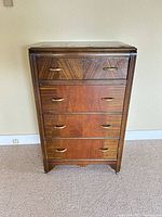 Front view of two-tone wood dresser showing four drawers and brass pulls
