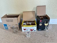 Three product boxes: Crisa tumblers, Bohemia Gina wine glasses, Le Choix du Président wine glasses with sample glasses displayed