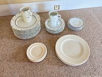 Overall view of stacked Sasaki plates, mugs, saucers, side plates and separate plain plates