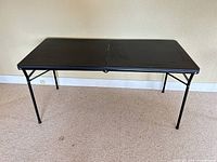 Full view of unfolded black folding table