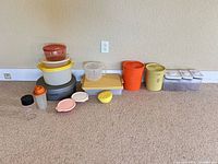 Full set of assorted plastic containers lined against wall