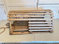 Side view of entire wooden lobster trap showing slat construction and mesh