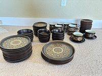 All stacks of plates, bowls, cups and saucers arranged on floor