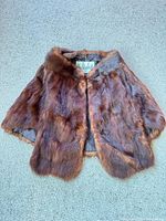 Front view of fur cape showing overall appearance and label