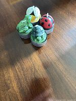 Group of four animal-shaped tealight candles on wooden surface