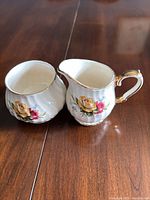 Fluted bone china creamer and sugar bowl showing rose transfers and gold trim