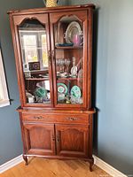 Full view of china cabinet showing upper glass doors, shelves, lower drawers and doors, cherry finish, cabriole feet