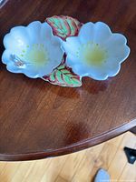 Top view of double flower-shaped porcelain dish showing bee accent and leaf connector