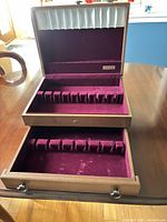 Chest open showing upper compartment, pull-out drawer, interior lining, utensil slots, Oneida plaque