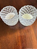 Pair of clear faceted glass candle holders with white candles