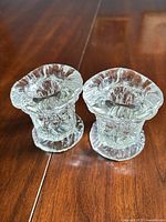Pair of clear pressed glass votive candle holders showing overall form and pressed pattern