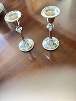 Pair of silver-plated candlesticks on tabletop