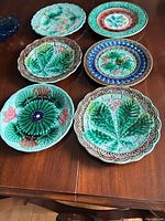 Six decorative plates displayed on table