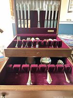 Open chest showing knives, forks, spoons in upper tray and serving pieces in lower drawer