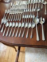 Flatware laid out showing knives, forks, spoons and serving pieces