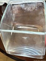 Square clear glass vase showing wear and clouding