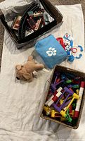 overview of all groups: train set in box, tote with doctor kit, plush dog, basket of connectors