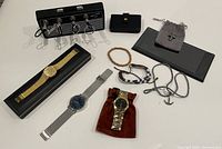 Entire lot laid out showing watches, jewellery, key holder, cases