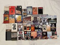 Wide shot of all 27 books laid out in four rows on white surface.