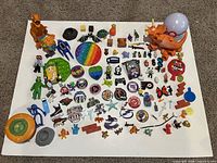 Entire lot overview showing all toys, fidgets, stickers and figures on white surface
