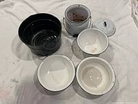 overall view of all enamelware pieces on cloth backdrop
