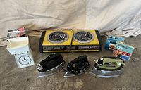 Group shot showing all items: three irons, hot plate, scale with box, two Parowax boxes
