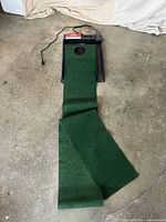 Full view of putting mat extended with base and power cord visible