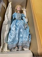 Full view of doll in box with tissue wrap