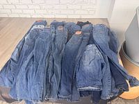 stacked assortment of denim jeans front view