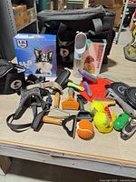 Overall lot view showing water fountain box, gear bag, grooming tools, bowls and toys
