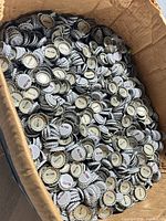 Open box full of Mr. Pibb bottle caps