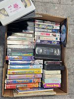 Overview of box filled with VHS tapes showing various movie titles