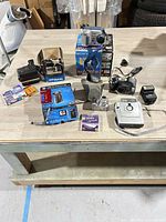Full view of all cameras, flash, film and accessories on table