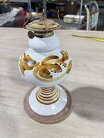 Full view of ceramic kerosene lamp base showing hand-painted design and brass burner