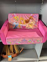 Front view of pink Disney Princess foam couch showing graphics of three princesses