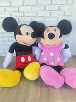 Mickey and Minnie plush dolls seated side by side