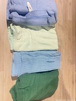 Stack of four blankets showing colors and textures