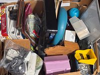 Overview of box showing assorted office supplies, binders, blue disc, plastic organizers, screws bag