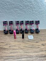 Group shot showing six boxed Sally Hansen Moist & Matte lip colors, pink lip balm, black lip crayon, white compact