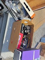 Overview of two boxes containing assorted electronics, cables and accessories