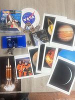 Entire lot overview showing prints, Hot Wheels pack, booklet, patch, coin, CD, fan, pin and sharpener