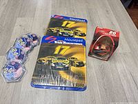 All items together: two sealed Matt Kenseth mouse pads, red boxed Tony Stewart ornament, four Jeff Gordon coasters