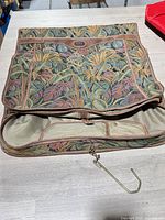 Full view of folded Passport tapestry garment bag showing hook and zipper