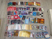 Wide view of entire collection laid out showing numerous sealed trading card sets and singles